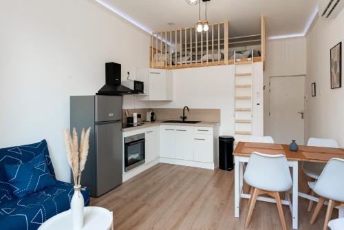 une cuisine et un salon avec une table et des chaises dans l'établissement MontSéjour - Superbe Apt climatisé Mezzanine, à Carcassonne