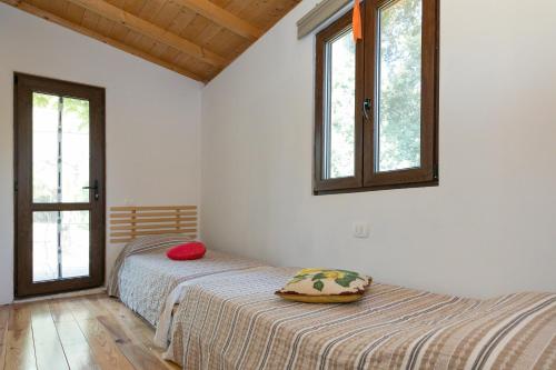 een slaapkamer met 2 bedden en 2 ramen bij La Poggiolina in Toscana in Guardistallo