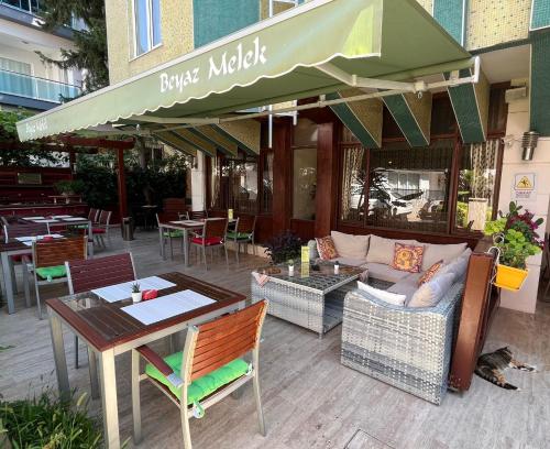 a patio with a couch and a table and chairs at Beyaz Melek Hotel in Antalya