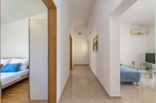 een hal die leidt naar een slaapkamer met een bed en een spiegel bij Sans Souci Split in Split