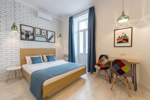 a bedroom with a bed and a table and chairs at Idea Design Apart-Hotel in Kyiv