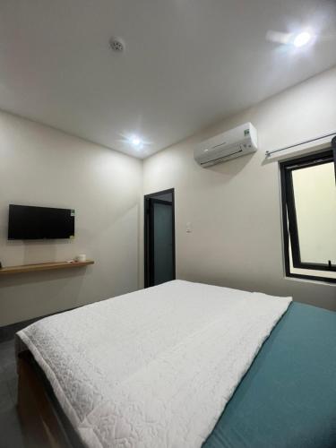 a bedroom with a white bed and a window at Thao Nguyen Homestay in Quy Nhon