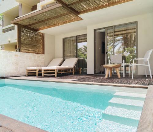 uma villa com uma piscina e um pátio em Tylissos Beach Hotel - Adults Only em Lerápetra