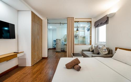 a bedroom with a bed and a tv and a couch at SaigonOne Serviced Apartment in Ho Chi Minh City