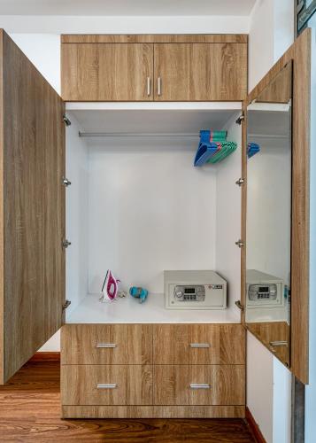 a kitchen with wooden cabinets and a microwave at SaigonOne Serviced Apartment in Ho Chi Minh City