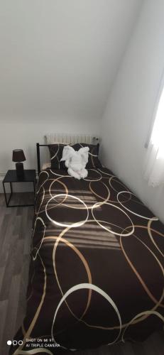 a bedroom with a bed with a brown and gold blanket at VILLA CLARETTE in Carhaix-Plouguer