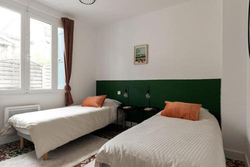 - une chambre avec 2 lits et une tête de lit verte dans l'établissement The Family Home, à Carcassonne