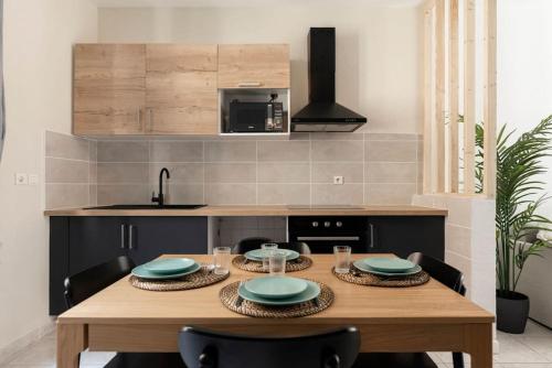 une cuisine avec une table en bois et des plaques de cuisson. dans l'établissement The Family Home, à Carcassonne