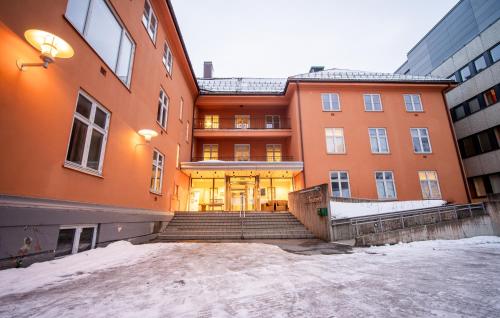 a large orange building with stairs in front of it at Enter St. Elisabeth Suites in Tromsø