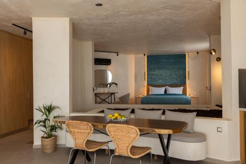 a room with a dining table and a bedroom at Anassa Ammoudi Suites in Agios Nikolaos