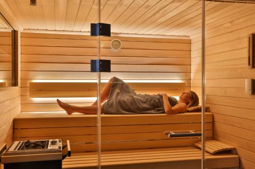 a woman is laying in a sauna at Eden du Boenlesgrab in Lautenbach
