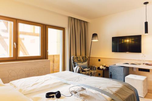 ein Hotelzimmer mit einem Bett mit Brille darauf in der Unterkunft Hotel Jägerhof in Zams