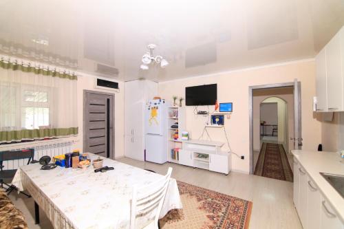 a white kitchen with a table and a refrigerator at Nomads Home in Bishkek