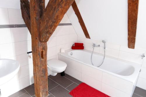 a bathroom with a tub and a toilet and a sink at Pension Altes Burghotel in Neustadt-Glewe