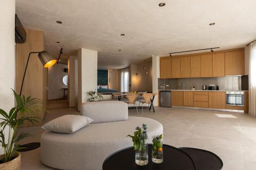 a living room with a couch and a kitchen at Anassa Ammoudi Suites in Agios Nikolaos
