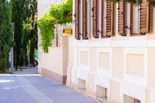 a building with a sidewalk next to a street at Antique Garden Villa in Split