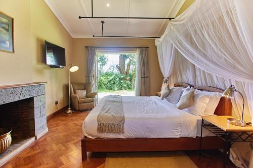 a bedroom with a canopy bed and a fireplace at Aero Club of East Africa in Nairobi