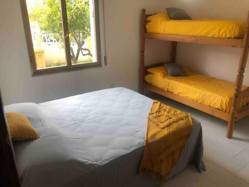 a bedroom with two bunk beds and a window at Under the Lemon Tree in La Caletta