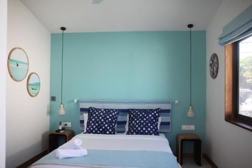 a blue bedroom with a bed and two mirrors at Blue Ocean Suites & Apartments in Trou dʼ Eau Douce