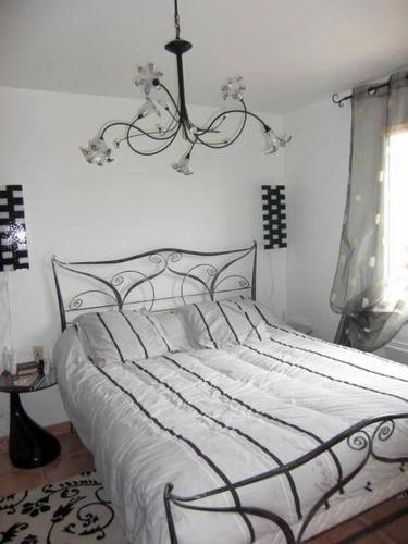 - une chambre avec un lit blanc et un lustre dans l'établissement Villa Climatisée de 2à 10 personnes Piscine privée 3km MER, à Hyères