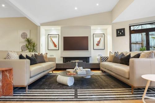 a living room with two couches and a tv at Elite Retreat Ponsonby with Parking and Deck in Auckland