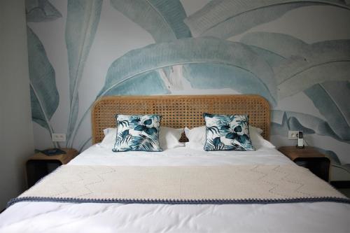 a bed with two pillows and a cat sitting on it at Blue Ocean Suites & Apartments in Trou dʼ Eau Douce
