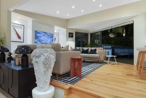 a living room with a couch and a table at Elite Retreat Ponsonby with Parking and Deck in Auckland