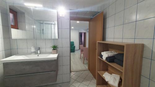 La salle de bains est pourvue d'un lavabo et d'un miroir. dans l'établissement Apartment Irene, à Sečovlje
