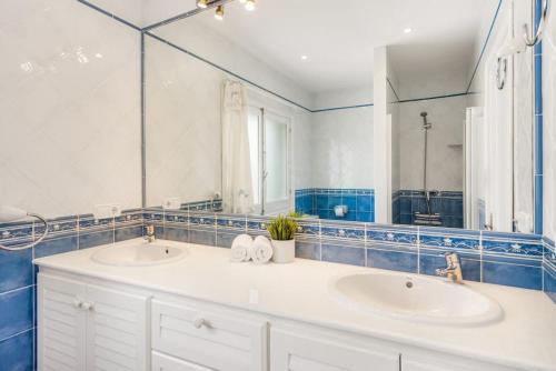 a bathroom with two sinks and a large mirror at S Olivera in Port d'Addaia