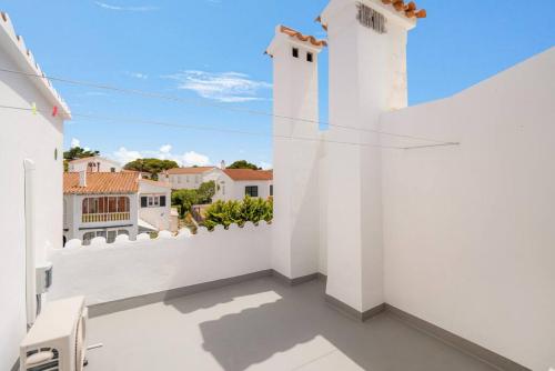 a white balcony with a view of a house at S Olivera in Port d'Addaia