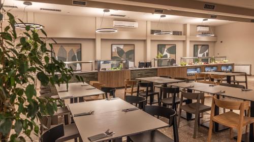 a restaurant with tables and chairs and a counter at Hotel Terme Jezercica in Donja Stubica