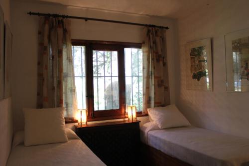 アレーナス・デ・サン・ペドロにあるRancho La Herraduraのベッドルーム1室(ベッド2台付)、窓(キャンドル付)