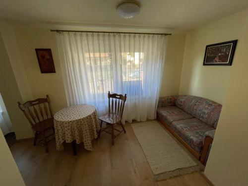 a living room with a couch and a table and chairs at Kristóf Vendégház in Bükkszék