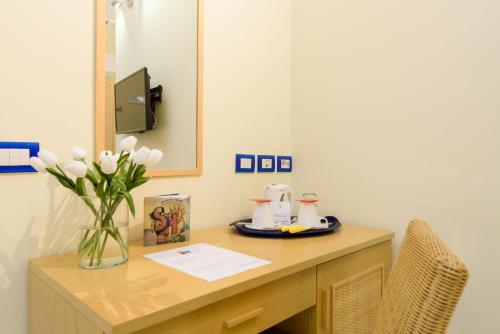 a desk with a vase of flowers and a mirror at Sharon House in Amalfi