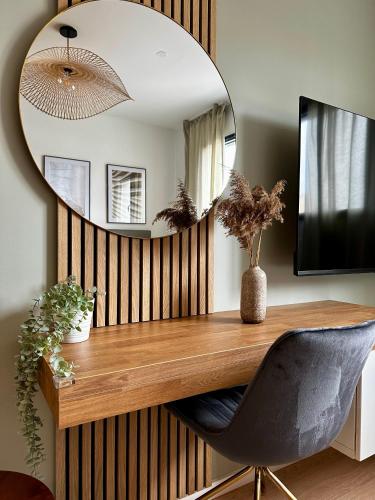 a mirror on a wall with a desk and a chair at Les Loges de la Mer - Pérols in Pérols