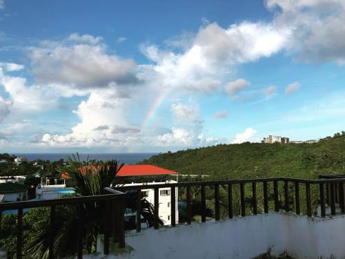 a rainbow in the sky over a house with a hill at SeaScape Port Blair in Port Blair