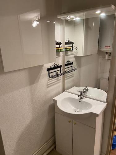 une salle de bain blanche avec un lavabo et un miroir dans l'établissement La Foux d'Allos - Studio 4 couchages - centre station, à Allos
