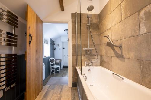 a bathroom with a bath tub and a shower at Church View in Nunnington