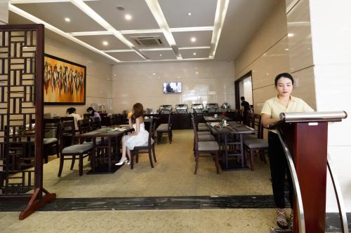 Ein Mann steht auf einem Podium in einem Restaurant. in der Unterkunft Golden Quang Tri Hotel in Ðông Hà