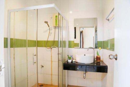 a bathroom with a sink and a shower at STAYHERE@AIRPORT SERVICE APARTMENT in Ban Bo Han