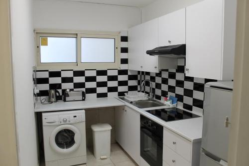 a kitchen with a washing machine and a sink at Stephanie City Apartments in Larnaca
