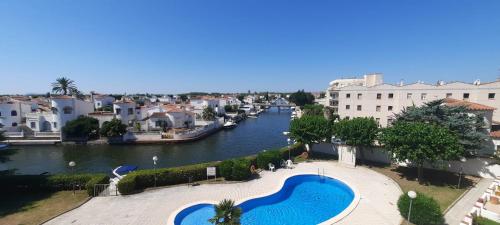 a view of a river with a pool and buildings at Appartement vue exceptionnelle sur les canaux in Empuriabrava