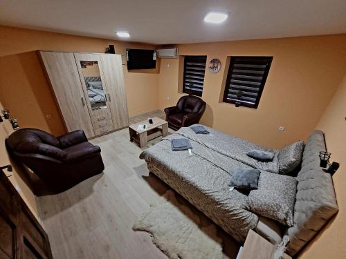 1 dormitorio con cama, sofá y sillas en Sobe - Palasthy, en Novi Bečej