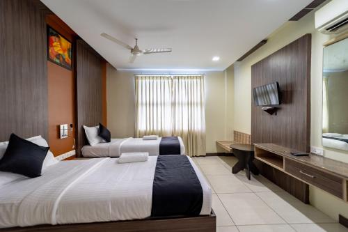 ein Hotelzimmer mit 2 Betten und einem TV in der Unterkunft Ranas Residency in Tiruchchirāppalli