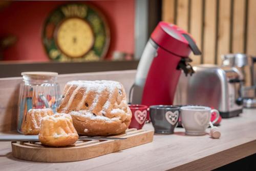 a table with a cutting board with pastries and a mixer at Le Kelsch, loft duplex 130m2, proche vignoble in Marlenheim