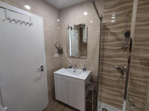 un baño con lavabo y ducha en 7C Castelo - Casas & Papeis, en Armação de Pêra