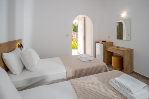 a white bedroom with two beds and a window at Amara Seaside by Estia in Malia