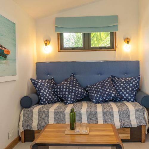 a blue couch with pillows and a table at Blue Ocean Suites & Apartments in Trou dʼ Eau Douce