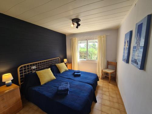 une chambre avec un lit bleu et une fenêtre dans l'établissement Apartment, short walk to the beach with aircon, à Calella de Palafrugell