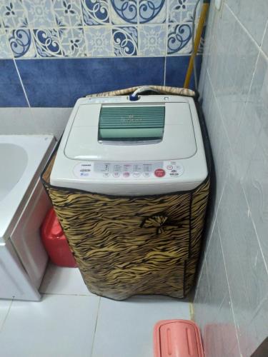 y lavadora en una cesta en el baño. en شقة مفروشة بالتجمع الخامس, en El Cairo